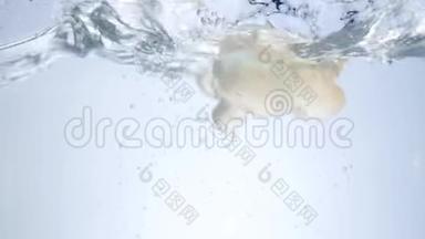 蘑菇掉进水里。 小蘑菇慢慢地掉进水里，造成水的飞溅和气泡